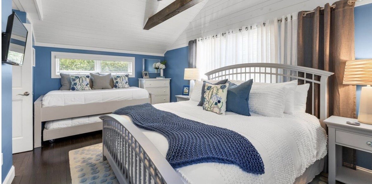 Blue lake house guest room with queen and daybed