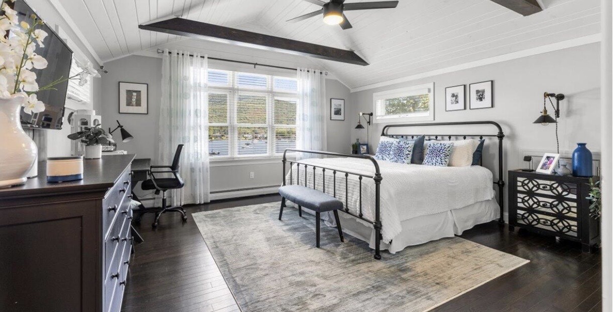 Lake house bedroom with vaulted shiplap ceiling